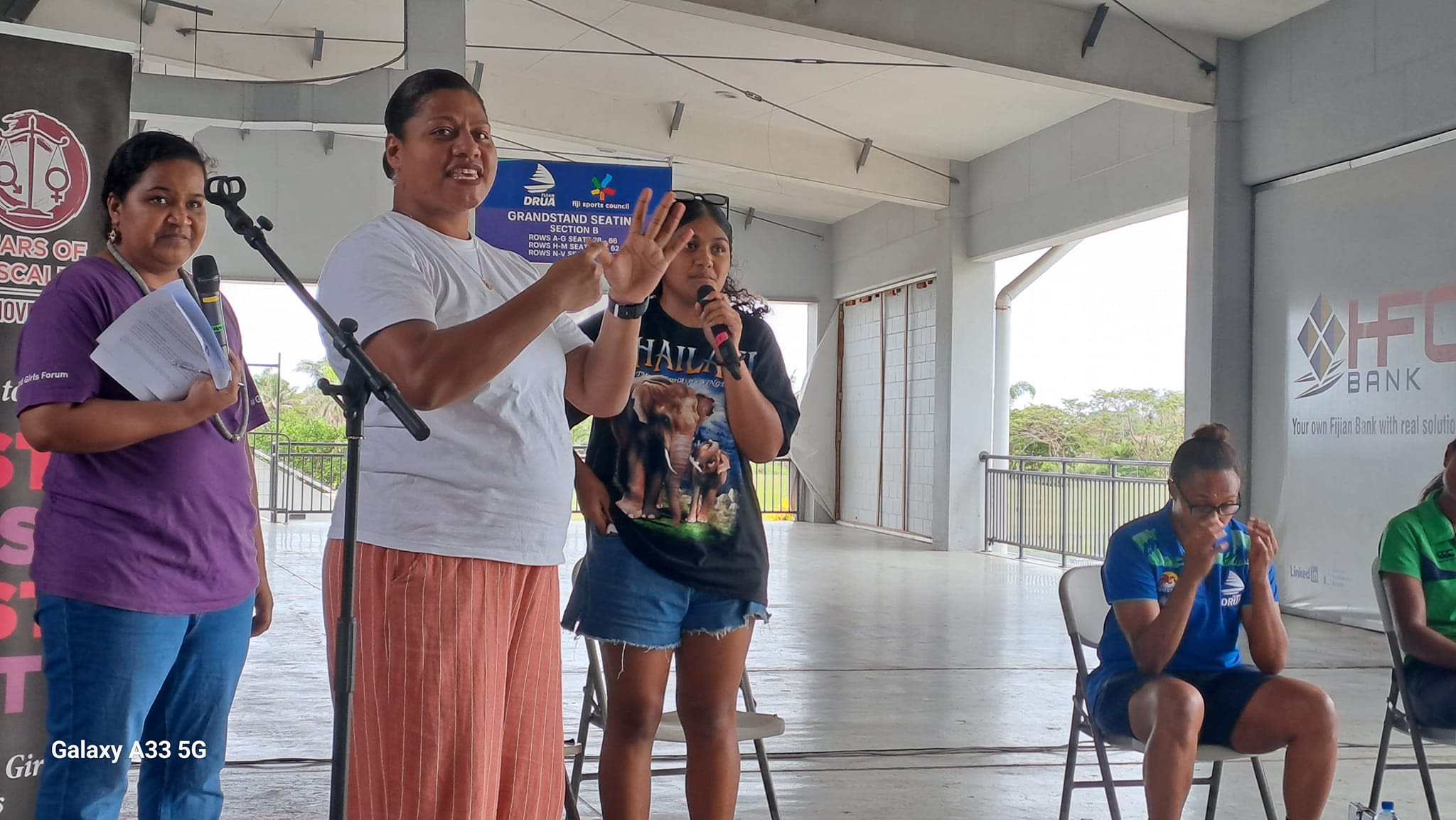 Speakers at FWRM's intergenerational panel. One of them is communicating with the crowd using Fijian Sign Language.