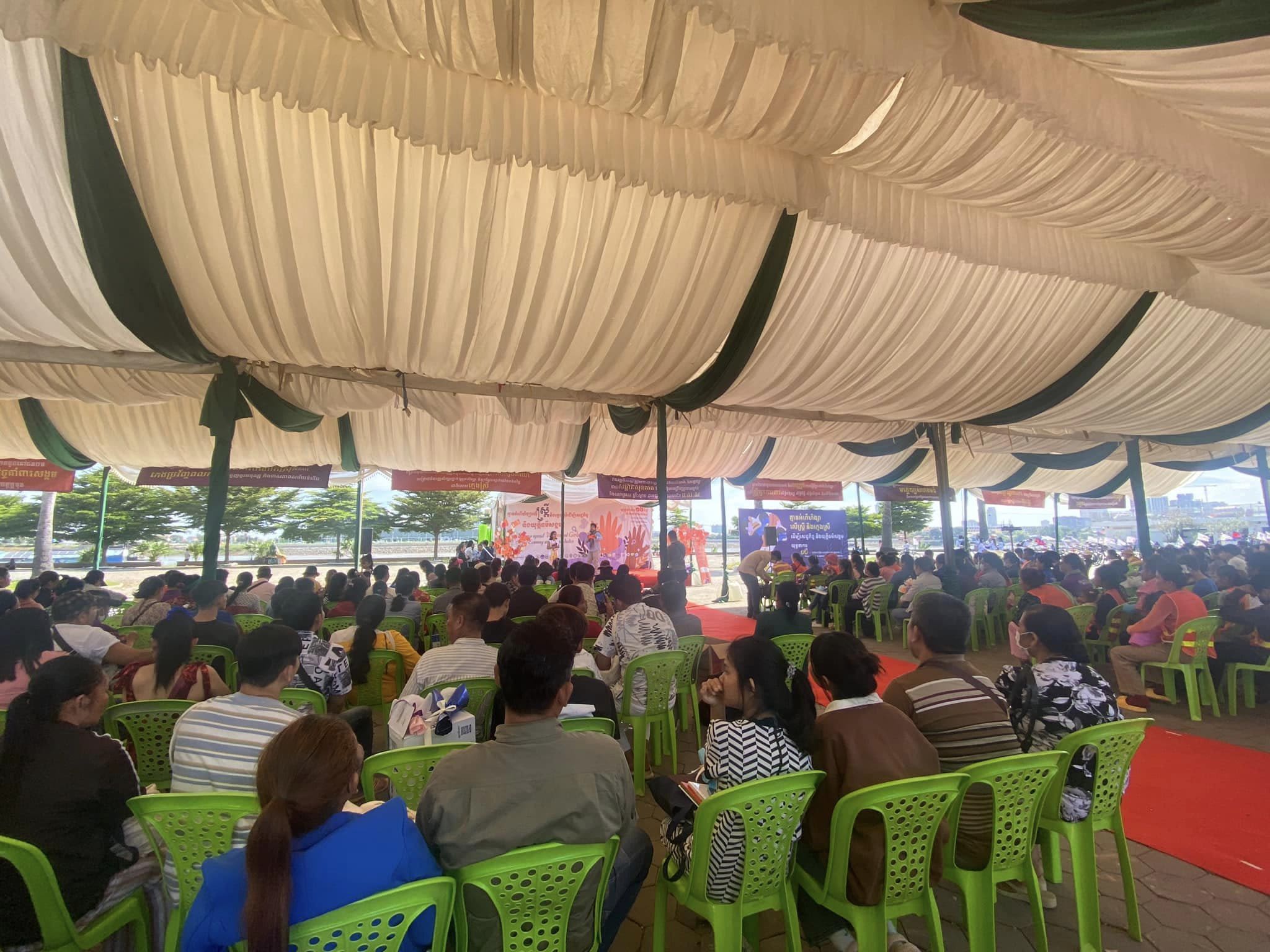 The crowd at the  ‘Non-violence Against Women and Girls for Economic and Social Justice’ event listening to someone presenting on stage.