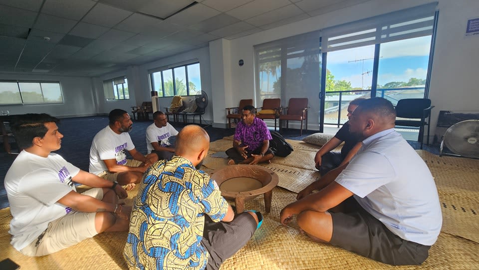 GIZ Pacific staff members sitting together on a woven mat.