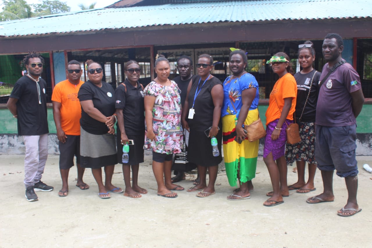 A group of men and woman posing together for the camera.