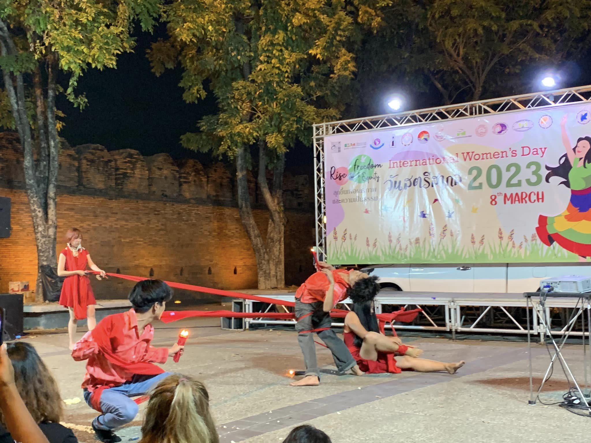 A group of four performers dressed in red dancing on stage for Women's League of Burma's International Women's Day event